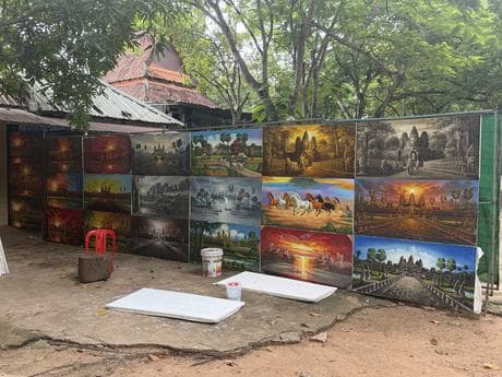 A wall of completed oil paintings outside the studio.
