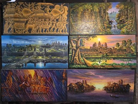 Framed oil paintings lining the studio wall.